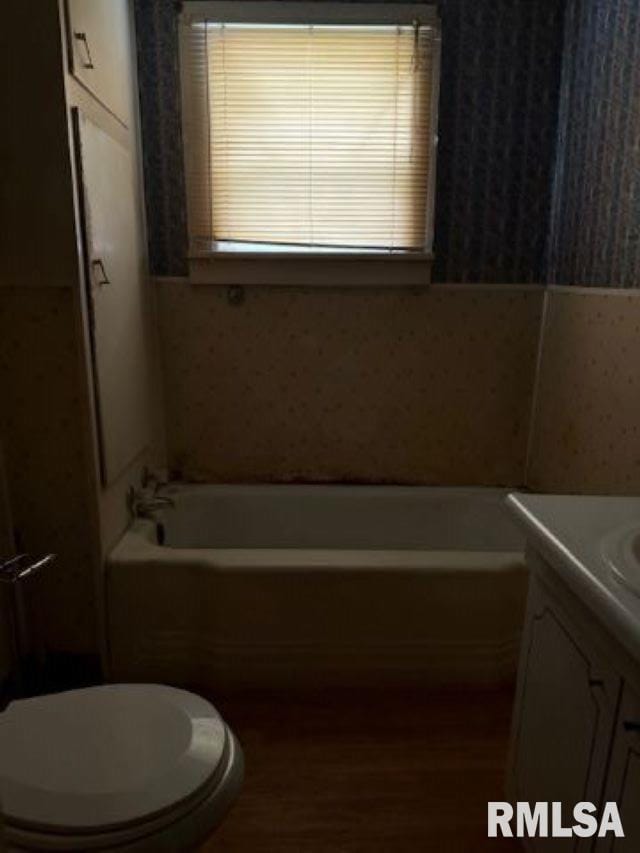 313 E 4th St, West Frankfort, IL 62896 - full bathroom with wallpapered walls, vanity, a tub to relax in, and wood finished floors