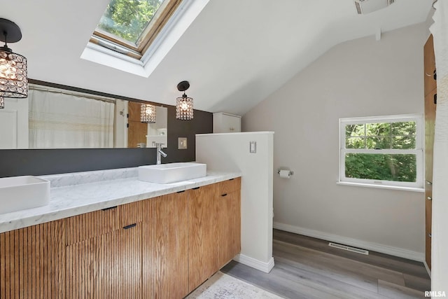 850 27th St, Rock Island, IL 61201 - full bath featuring lofted ceiling, a skylight, vanity, wood finished floors, and curtained shower