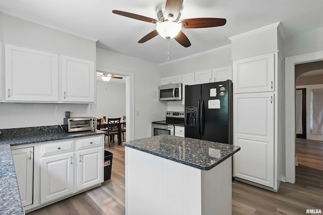 850 27th St, Rock Island, IL 61201 - kitchen with appliances with stainless steel finishes, ceiling fan, wood finished floors, white cabinetry, and arched walkways