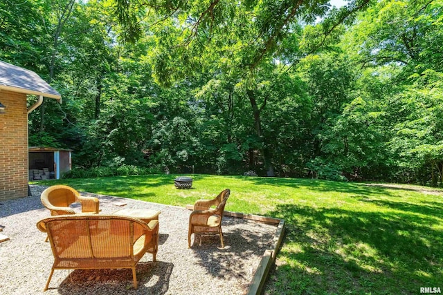 850 27th St, Rock Island, IL 61201 - view of grassy yard featuring a patio, a storage shed, and a view of trees