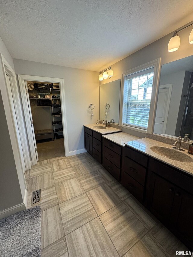 10509 N Butterfly Dr, Dunlap, IL 61525 - full bathroom featuring vanity, a textured ceiling, and a spacious closet
