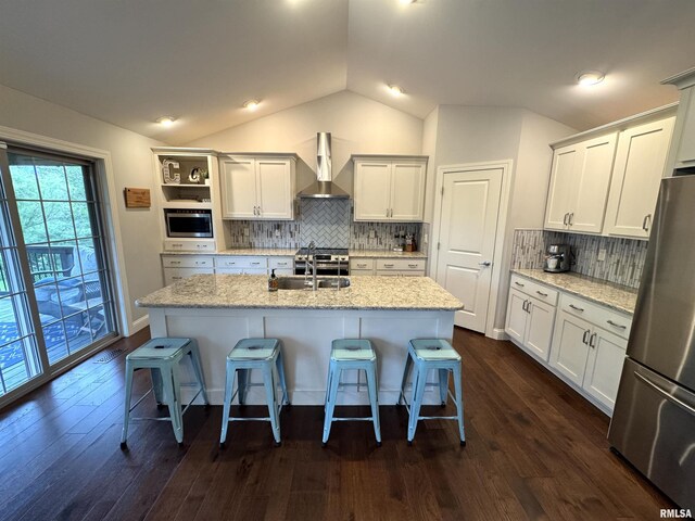 10509 N Butterfly Dr, Dunlap, IL 61525 - kitchen featuring appliances with stainless steel finishes, wall chimney exhaust hood, vaulted ceiling, open shelves, and a kitchen bar
