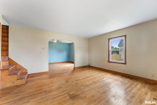 204 E Main St, Joy, IL 61260 - unfurnished room featuring arched walkways, light wood-style flooring, and stairway