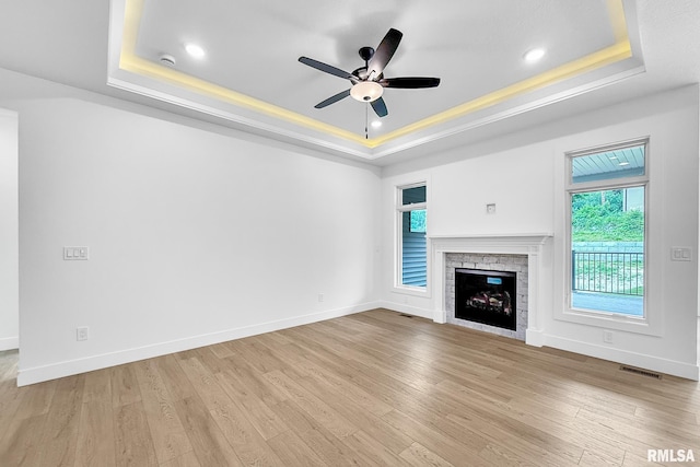 1354 Heights Ct, Bettendorf, IA 52722 - unfurnished living room with a tray ceiling, ceiling fan, a stone fireplace, light wood finished floors, and recessed lighting