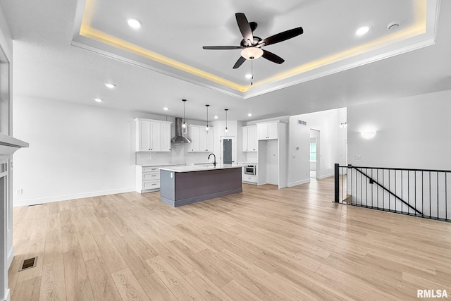 1354 Heights Ct, Bettendorf, IA 52722 - kitchen featuring wall chimney range hood, a raised ceiling, ceiling fan, recessed lighting, and a center island with sink
