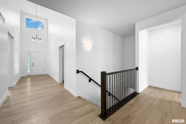 1354 Heights Ct, Bettendorf, IA 52722 - hallway featuring an upstairs landing, a chandelier, light wood-style flooring, and a high ceiling
