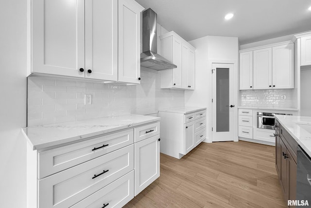 1354 Heights Ct, Bettendorf, IA 52722 - kitchen with wall chimney range hood, light stone countertops, decorative backsplash, light wood-style flooring, and appliances with stainless steel finishes