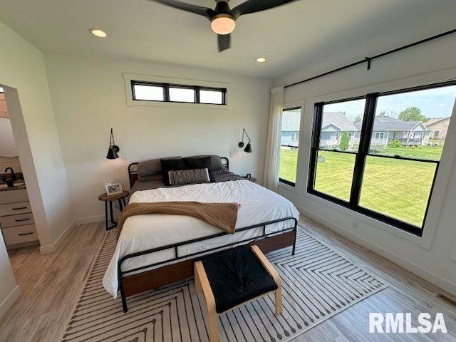 1722 17th St, De Witt, IA 52742 - bedroom featuring multiple windows, light wood-type flooring, recessed lighting, and ceiling fan