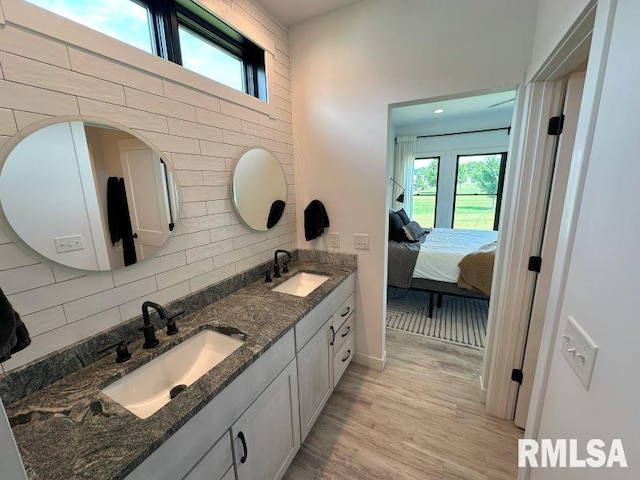 1722 17th St, De Witt, IA 52742 - bathroom with double vanity, decorative backsplash, connected bathroom, and wood finished floors