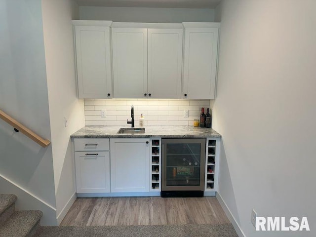 1722 17th St, De Witt, IA 52742 - indoor dry bar with wine cooler, light wood-type flooring, decorative backsplash, and stairway