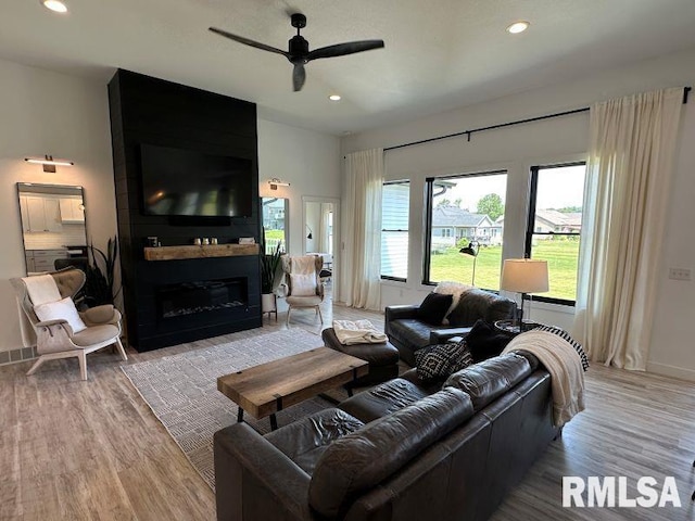 1722 17th St, De Witt, IA 52742 - living room featuring light wood-style flooring, a ceiling fan, a fireplace, and recessed lighting