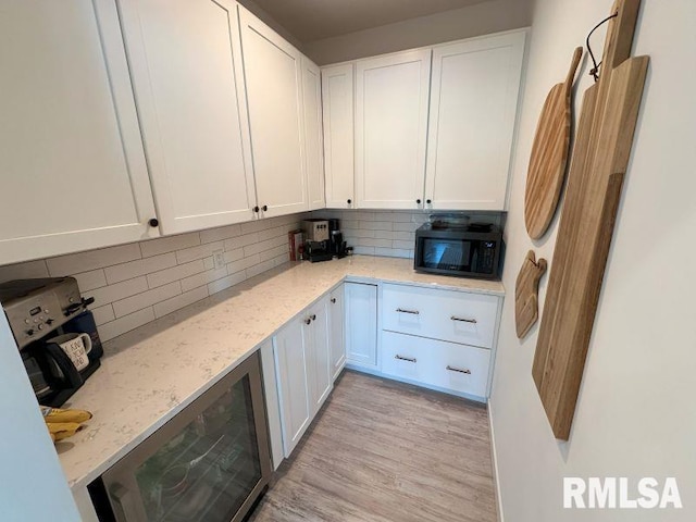 1722 17th St, De Witt, IA 52742 - kitchen with black microwave, wine cooler, tasteful backsplash, and white cabinetry