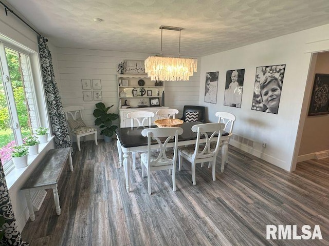 1144 Brookview Dr, De Witt, IA 52742 - dining space with a chandelier, dark wood-style floors, a textured ceiling, and wood walls