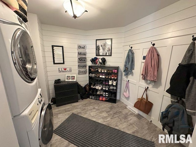1144 Brookview Dr, De Witt, IA 52742 - laundry room with estacked washer and dryer, light wood-style floors, and wood walls