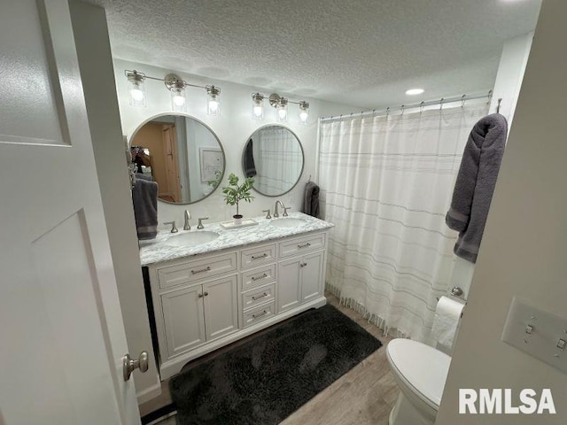 1144 Brookview Dr, De Witt, IA 52742 - full bath featuring wood finished floors, double vanity, a textured ceiling, and a shower with curtain