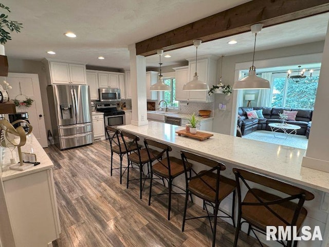 1144 Brookview Dr, De Witt, IA 52742 - kitchen with appliances with stainless steel finishes, dark wood-style floors, white cabinetry, recessed lighting, and beam ceiling