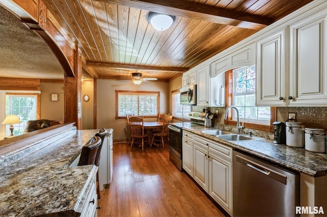 1445 Lawrence Ave, Camanche, IA 52730 - kitchen featuring appliances with stainless steel finishes, wooden ceiling, plenty of natural light, tasteful backsplash, and arched walkways
