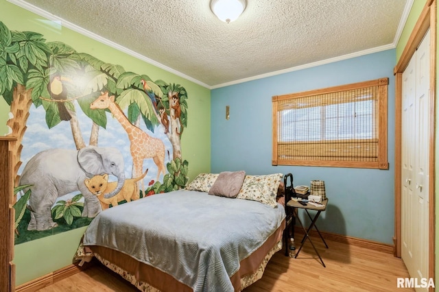 1445 Lawrence Ave, Camanche, IA 52730 - bedroom featuring a closet, wood finished floors, a textured ceiling, and ornamental molding