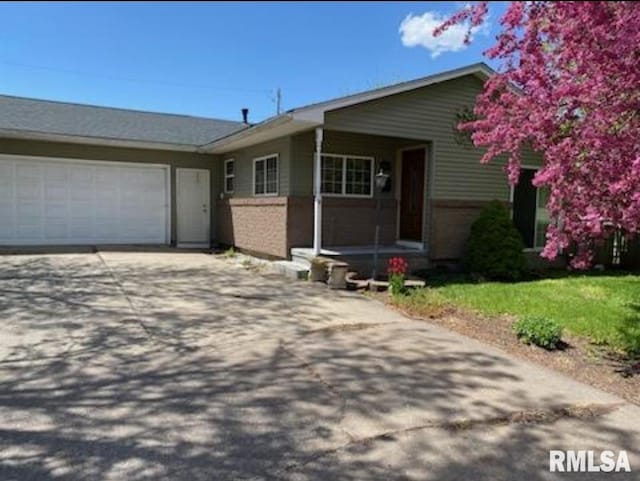 1445 Lawrence Ave, Camanche, IA 52730 - ranch-style house with driveway, an attached garage, and a front yard