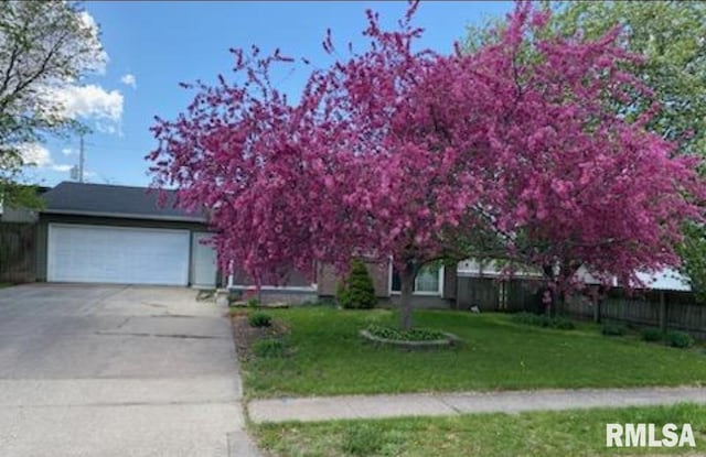 1445 Lawrence Ave, Camanche, IA 52730 - view of property hidden behind natural elements featuring concrete driveway and a garage