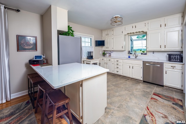 13524 US Route 67, Milan, IL 61264 - kitchen with stainless steel appliances, a breakfast bar, white cabinetry, and a peninsula