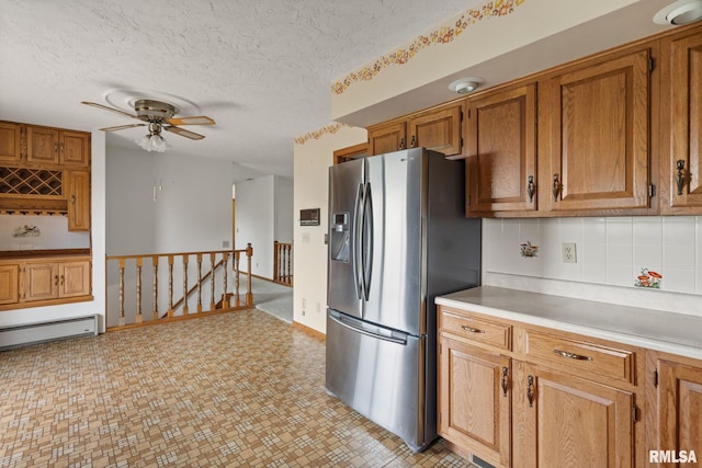 20425 20th Ave, Stockton, IA 52769 - kitchen featuring stainless steel fridge with ice dispenser, light countertops, brown cabinets, and a textured ceiling