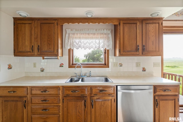 20425 20th Ave, Stockton, IA 52769 - kitchen with stainless steel dishwasher, brown cabinetry, light countertops, and plenty of natural light