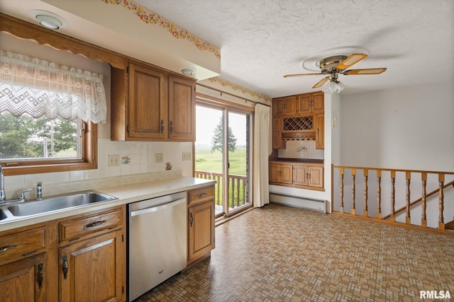 20425 20th Ave, Stockton, IA 52769 - kitchen with dishwasher, a baseboard radiator, ceiling fan, brown cabinetry, and light countertops