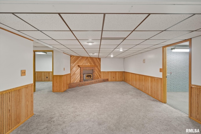 20425 20th Ave, Stockton, IA 52769 - finished basement featuring a wainscoted wall, wood walls, carpet, a fireplace, and a drop ceiling