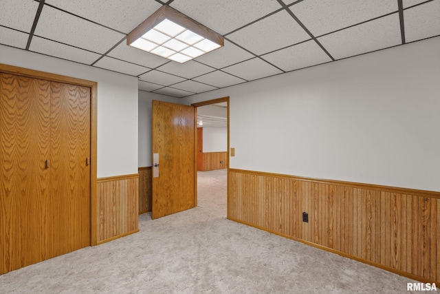 20425 20th Ave, Stockton, IA 52769 - unfurnished room with a wainscoted wall, a drop ceiling, carpet, and wood walls