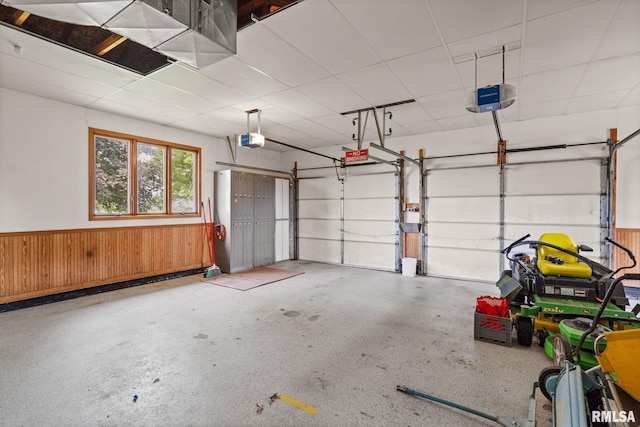 20425 20th Ave, Stockton, IA 52769 - garage featuring a garage door opener, wainscoting, and wooden walls