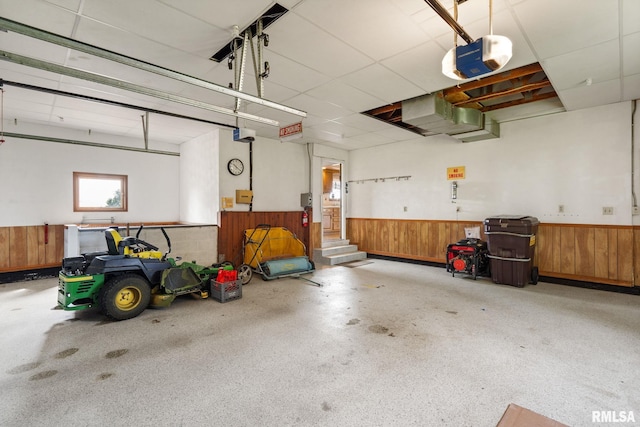 20425 20th Ave, Stockton, IA 52769 - garage featuring a wainscoted wall, wooden walls, and a garage door opener