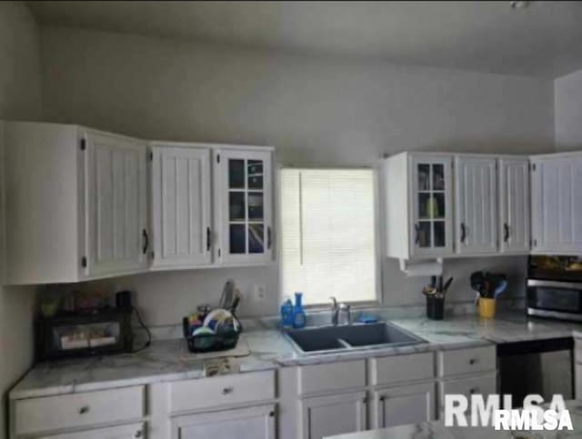 701 3rd St, Seaton, IL 61476 - kitchen featuring white cabinetry, stainless steel microwave, light countertops, and glass insert cabinets