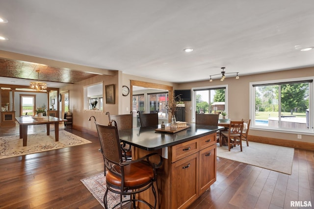 3473 270th St, De Witt, IA 52742 - kitchen featuring dark wood finished floors, a breakfast bar, dark countertops, a chandelier, and recessed lighting