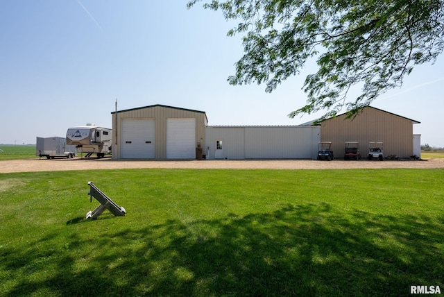 3473 270th St, De Witt, IA 52742 - view of grassy yard featuring an outbuilding and a garage