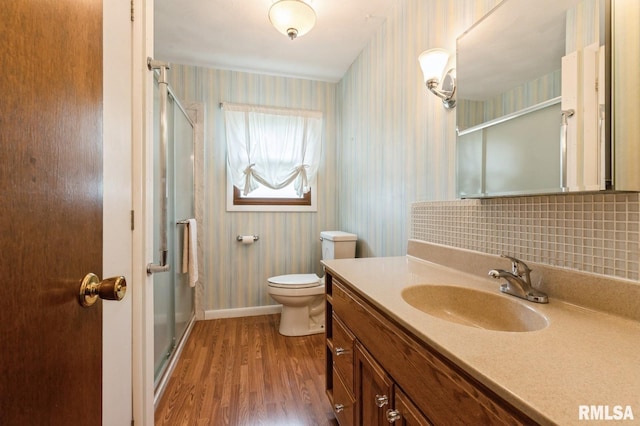 1031 15th Pl, Camanche, IA 52730 - bathroom with wallpapered walls, a stall shower, vanity, wood finished floors, and decorative backsplash