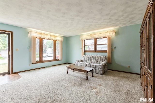 1031 15th Pl, Camanche, IA 52730 - carpeted living area with healthy amount of natural light and a textured ceiling