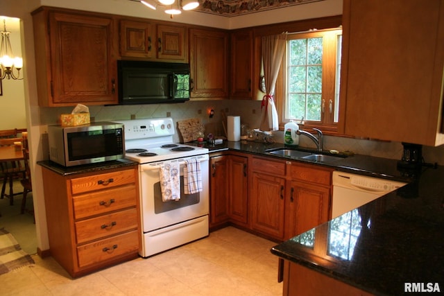 4145 Aspen Hills Dr, Bettendorf, IA 52722 - kitchen featuring white appliances, a chandelier, tasteful backsplash, brown cabinets, and dark stone counters