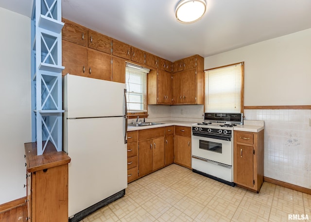 430 10th Pl, Camanche, IA 52730 - kitchen with white appliances, brown cabinets, light countertops, and tile walls