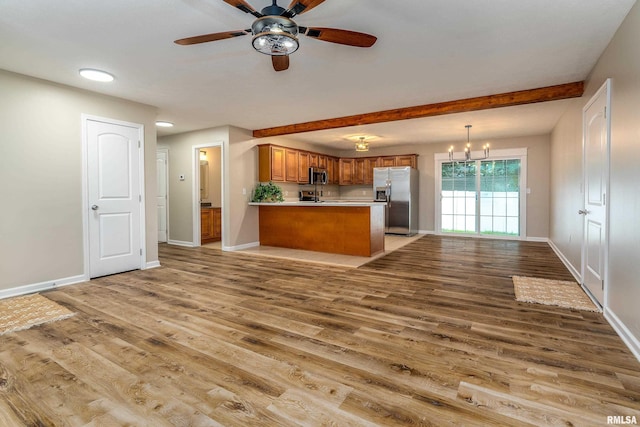 1321 N 7th St, Herrin, IL 62948 - kitchen with stainless steel appliances, brown cabinetry, light wood-style flooring, a peninsula, and a ceiling fan