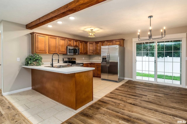 1321 N 7th St, Herrin, IL 62948 - kitchen featuring stainless steel appliances, a peninsula, a chandelier, brown cabinetry, and recessed lighting