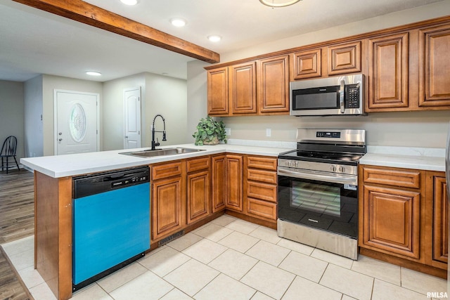 1321 N 7th St, Herrin, IL 62948 - kitchen with stainless steel appliances, a peninsula, brown cabinetry, beam ceiling, and light countertops