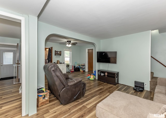 3020 Cleveland St, Clinton, IA 52732 - living area with arched walkways, wood finished floors, stairs, and ceiling fan
