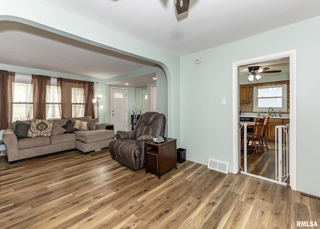 3020 Cleveland St, Clinton, IA 52732 - living area featuring arched walkways, wood finished floors, and a ceiling fan