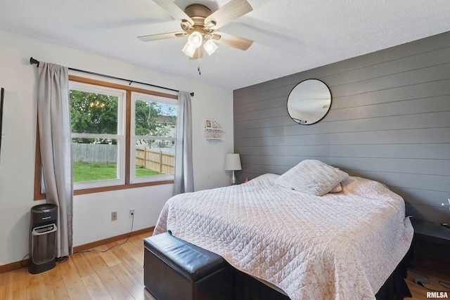 1426 W 48th St, Davenport, IA 52806 - bedroom featuring light wood-style flooring, wood walls, and ceiling fan