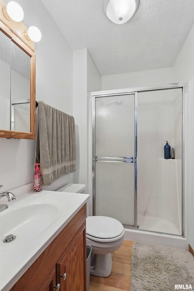 1426 W 48th St, Davenport, IA 52806 - full bathroom with wood finished floors, vanity, a shower stall, and a textured ceiling