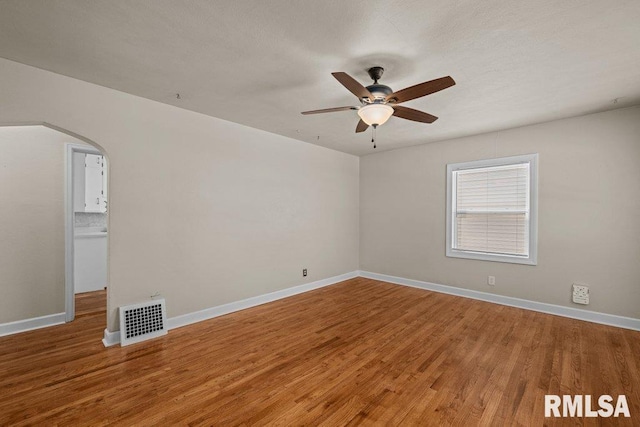 516 19th Ave, Rock Island, IL 61201 - empty room featuring arched walkways, ceiling fan, and wood finished floors