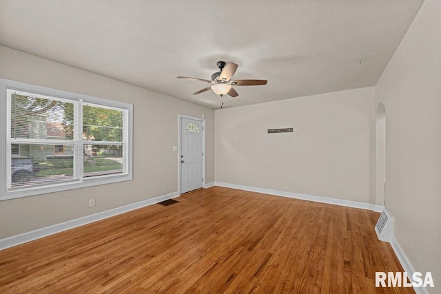 516 19th Ave, Rock Island, IL 61201 - spare room with light wood finished floors, arched walkways, and a ceiling fan