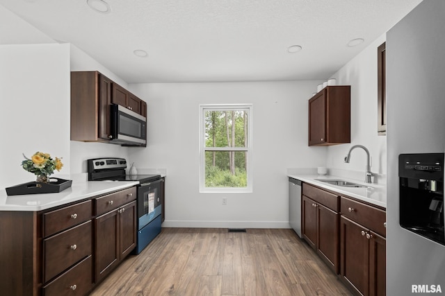 813 Williams Way, Carbon Cliff, IL 61239 - kitchen with appliances with stainless steel finishes, light wood-style floors, light countertops, and dark brown cabinetry