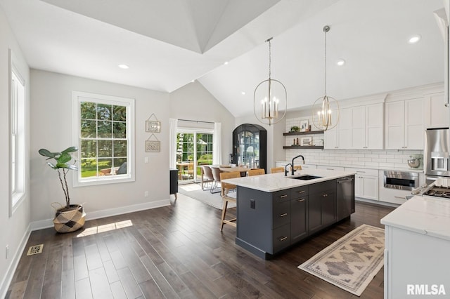6925 Grover Sta, Bettendorf, IA 52722 - kitchen with stainless steel appliances, white cabinetry, vaulted ceiling, a kitchen island with sink, and a chandelier